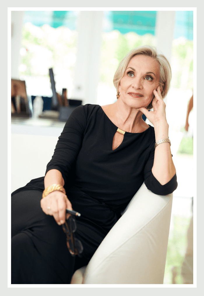 A woman sitting on the chair talking on her phone.